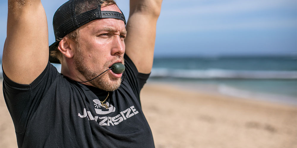 A person using a Jawzrsize device on the beach