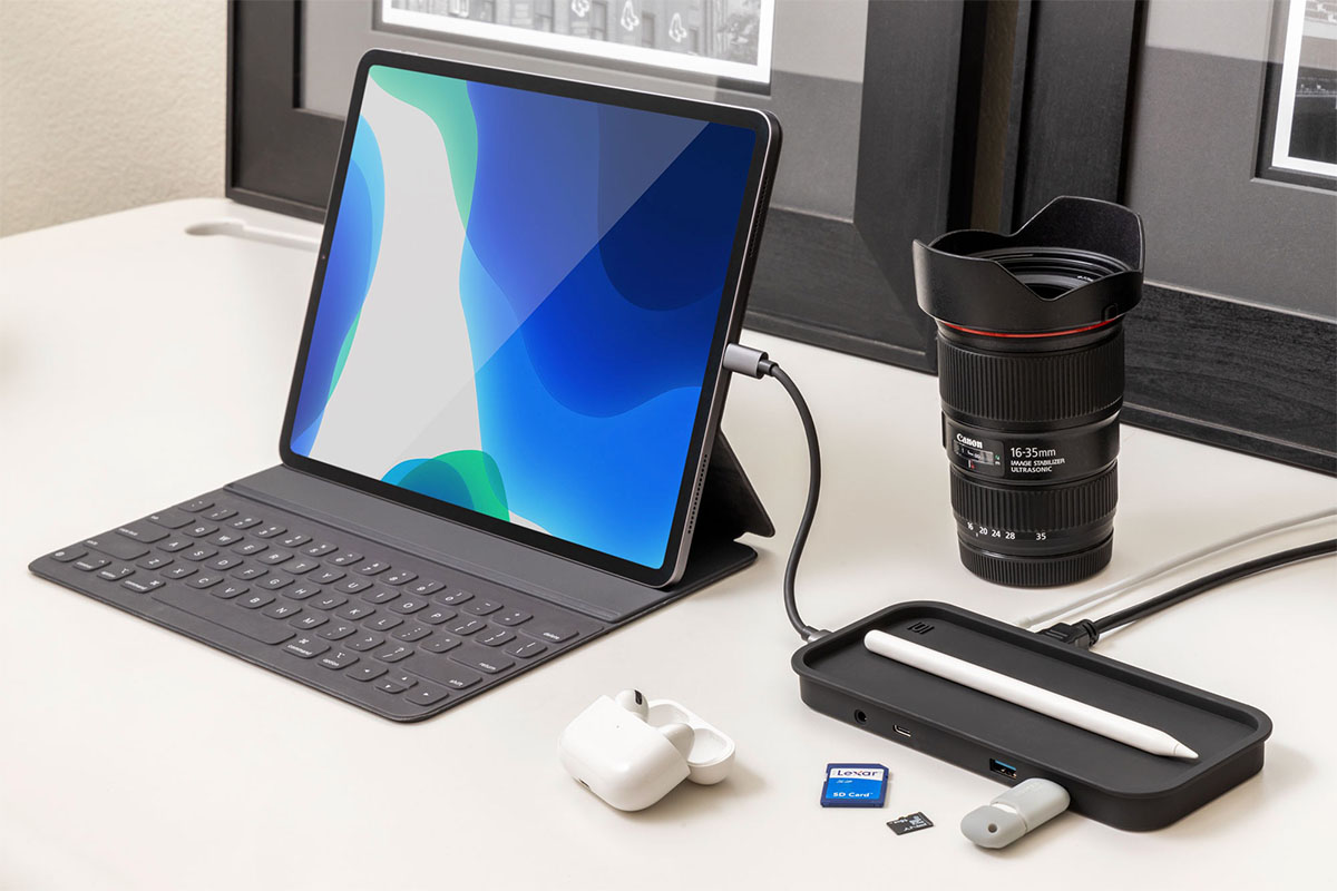 A desk, with a tablet charging and other tech accessories